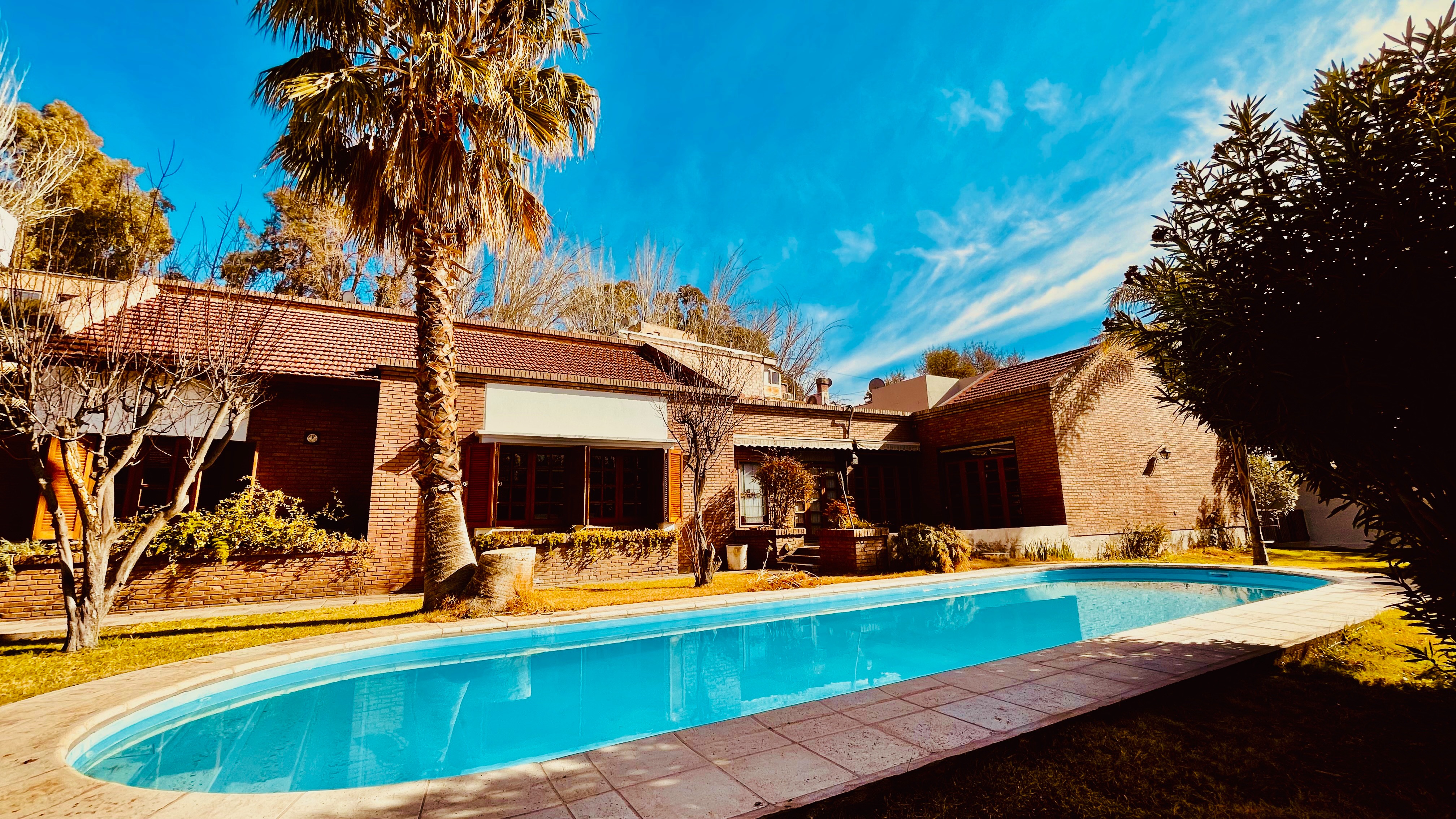 Piscina exterior de Blue Sky rodeada de vegetación