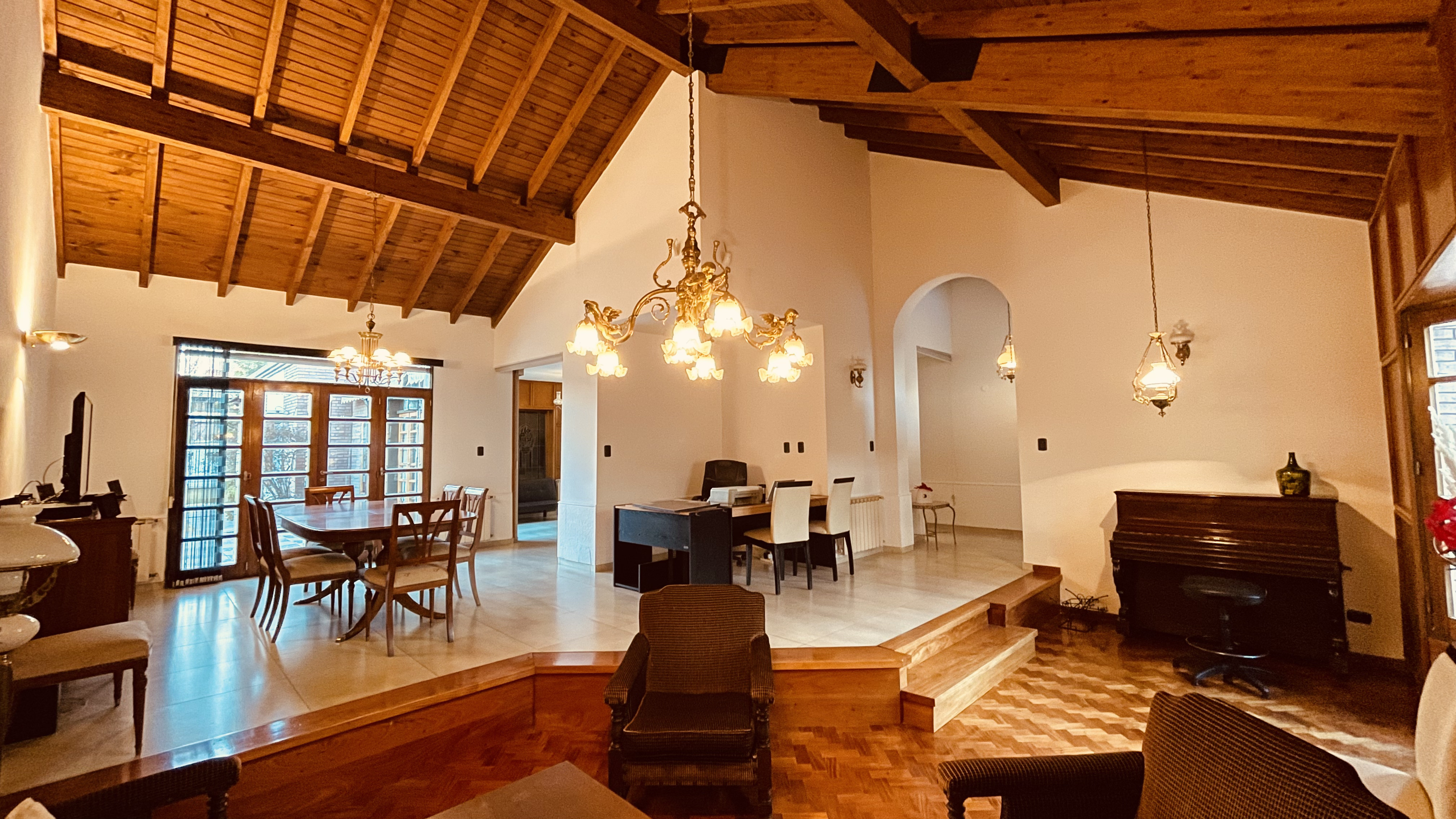 Salón amplio con techo de madera, comedor y estar